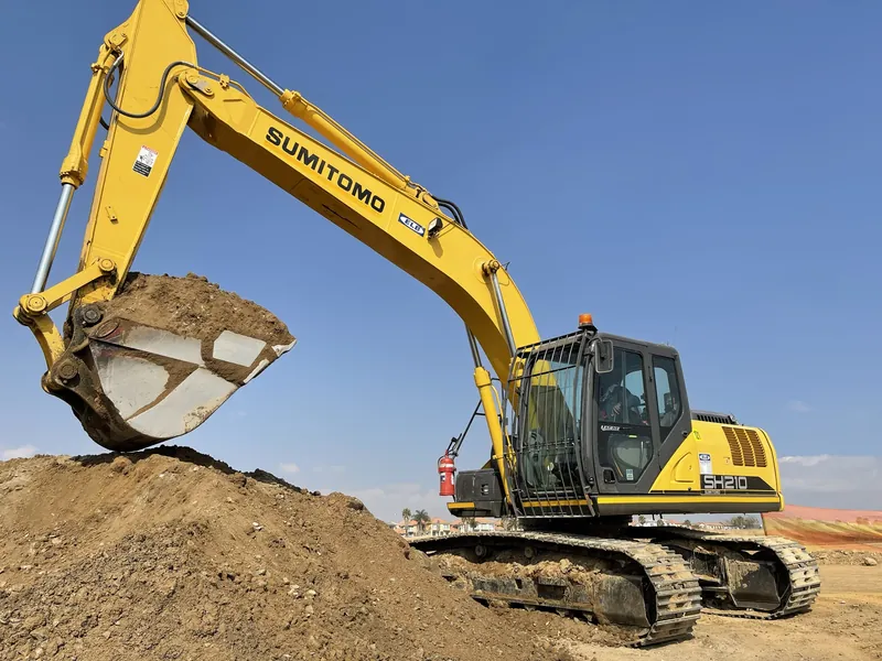 Yellow WNR excavator on site with a full bucket raised