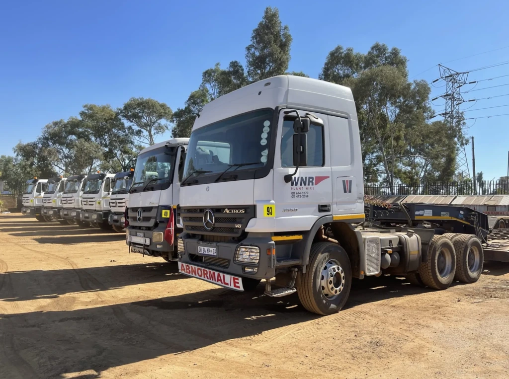 White WNR truck tractors lined up in the yard