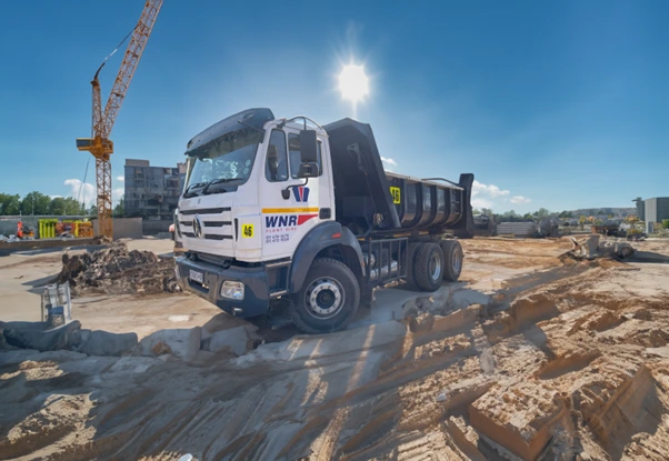 WNR tipper truck on a site with a crane behind