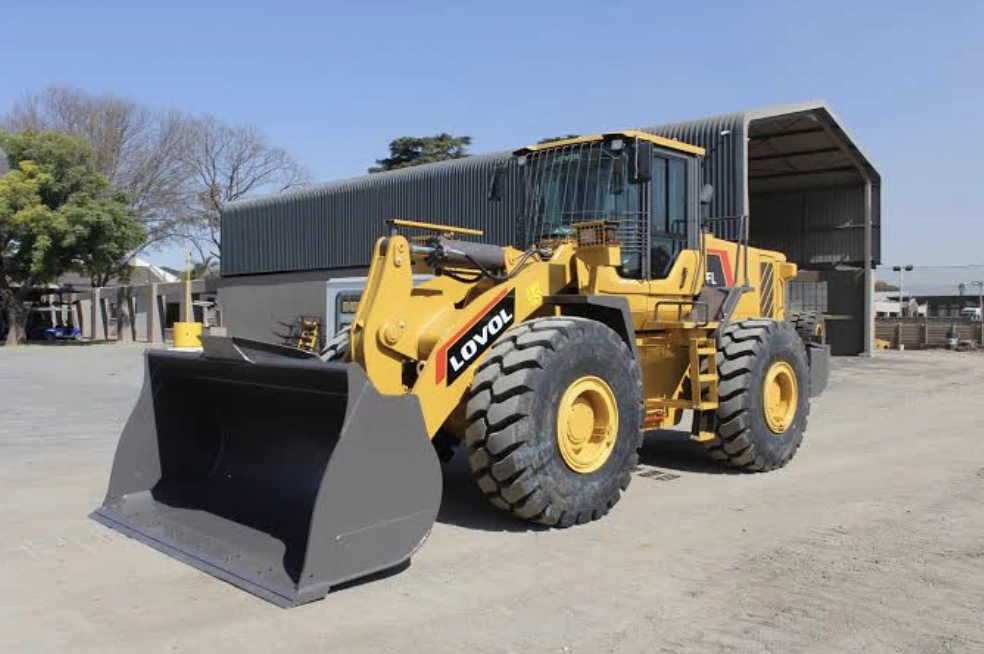 Yellow wheel loader with a large bucket parked in a yard